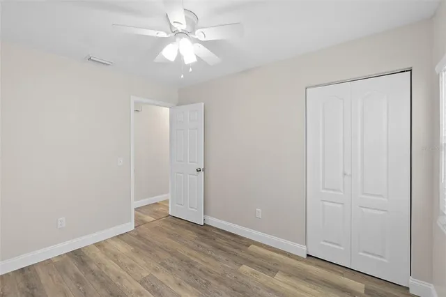 an empty room with a window and ceiling fan