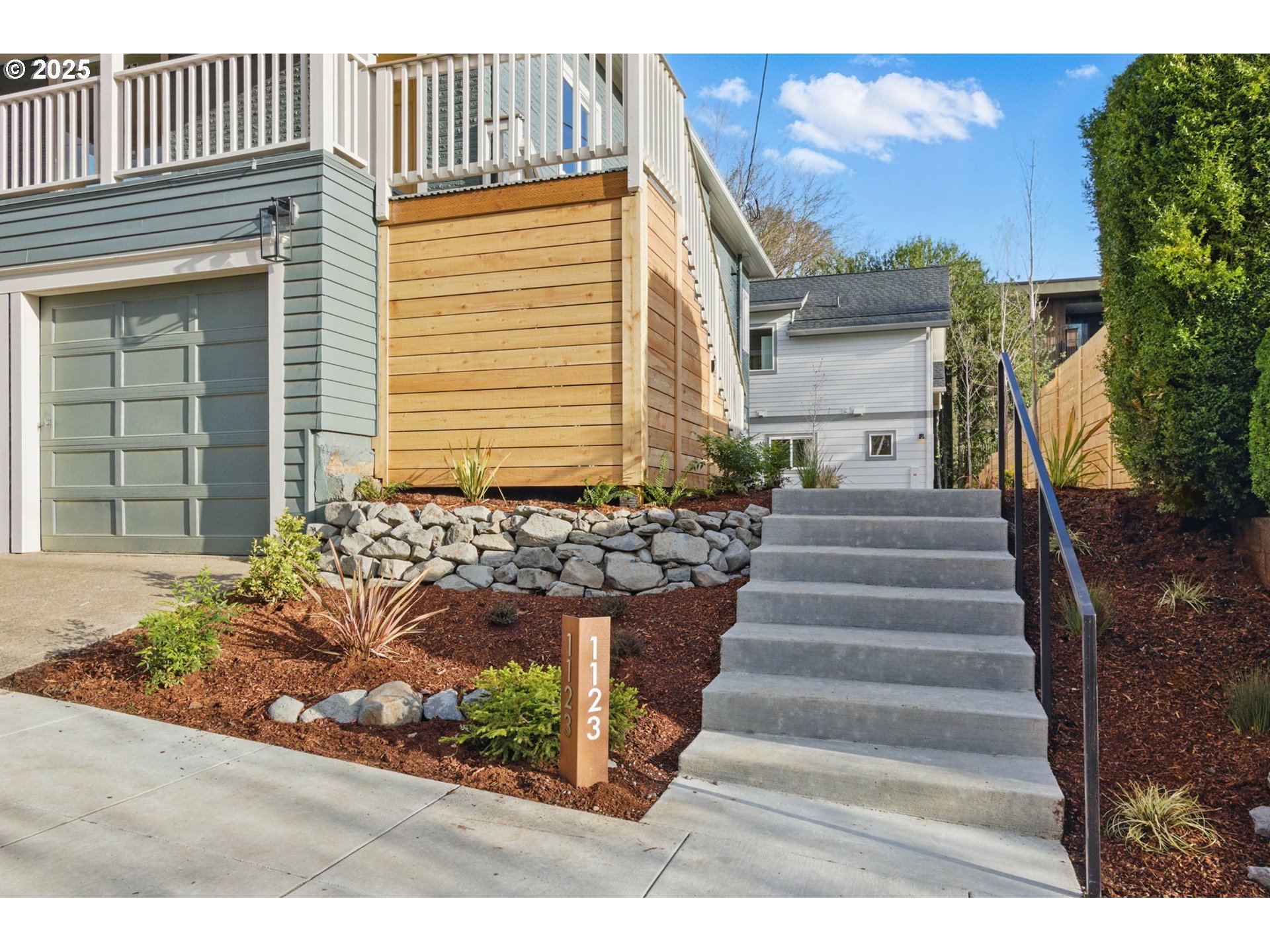1123 Southeast Rhone Street, Unit B Portland, OR 97202 - Photo 21 of 22 a front view of a house with a yard and garage