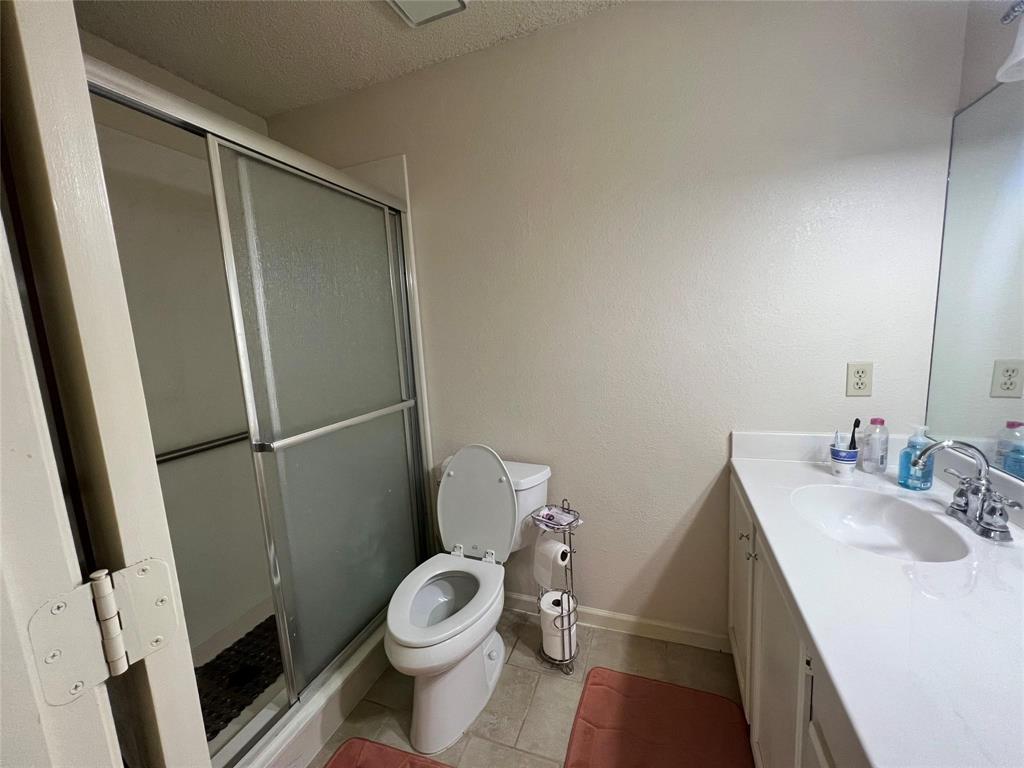 3129 Sappington Place Fort Worth, TX 76116 - Photo 10 of 15 Full bath featuring a textured ceiling, vanity, a stall shower, light tile patterned flooring, and a textured wall