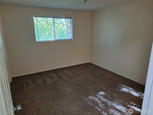 a bathroom with a granite countertop toilet sink and mirror