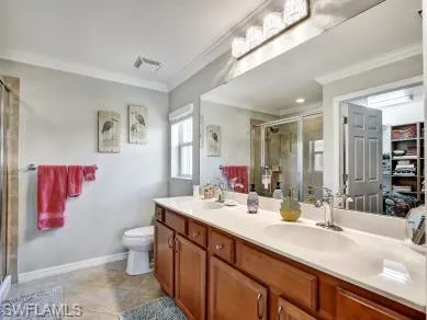a bathroom with a double vanity sink mirror and toilet