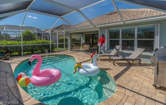 8693 Querce Court Naples, FL 34114 - Photo 26 of 50 a view of a backyard with table and chairs under an umbrella