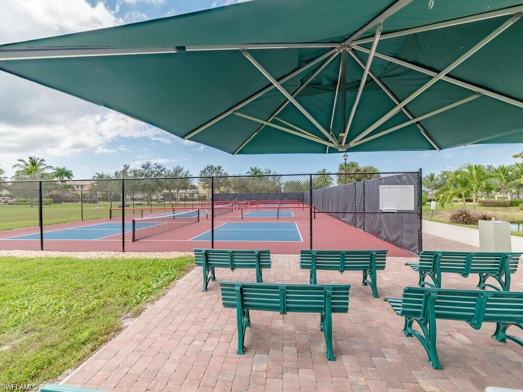 8693 Querce Court Naples, FL 34114 - Photo 39 of 50 a view of a yard with a table and chairs under an umbrella
