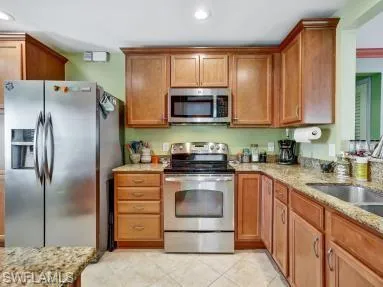 a kitchen with stainless steel appliances granite countertop a stove a refrigerator and a sink