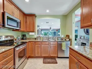 a kitchen with stainless steel appliances granite countertop a stove a sink and a microwave