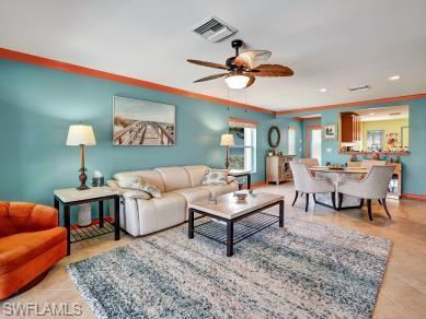 8693 Querce Court Naples, FL 34114 - Photo 9 of 50 a living room with furniture a rug and a chandelier
