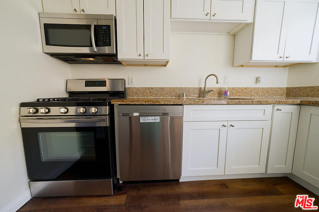 a kitchen with stainless steel appliances granite countertop a stove a microwave and cabinets
