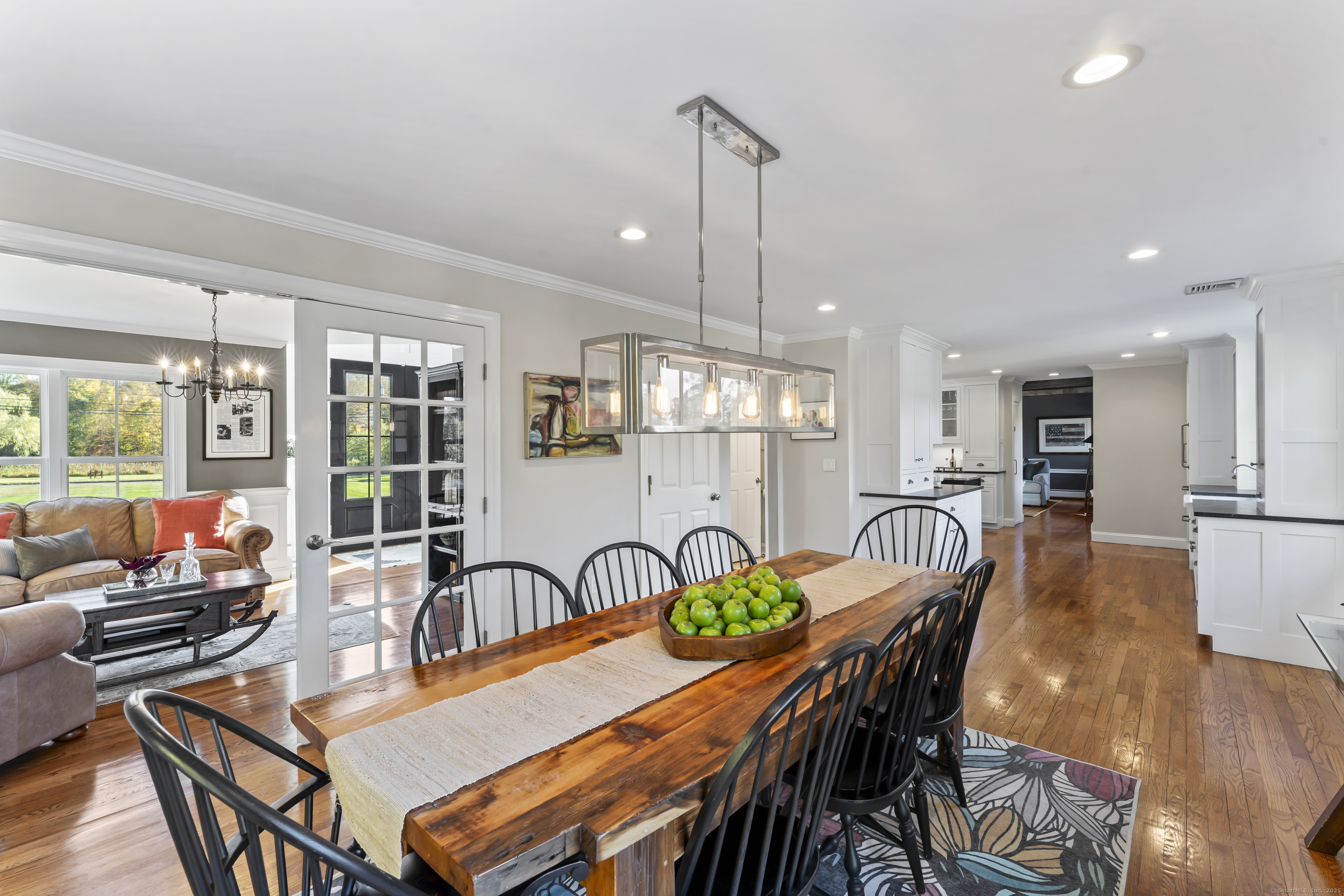 40 Great Ring Road Newtown, CT 06482 - Photo 14 of 39 a view of a dining room and livingroom with furniture wooden floor a rug a potted plant and a chandelier