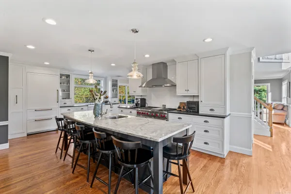 a large kitchen with stainless steel appliances granite countertop a lot of counter space and wooden floors