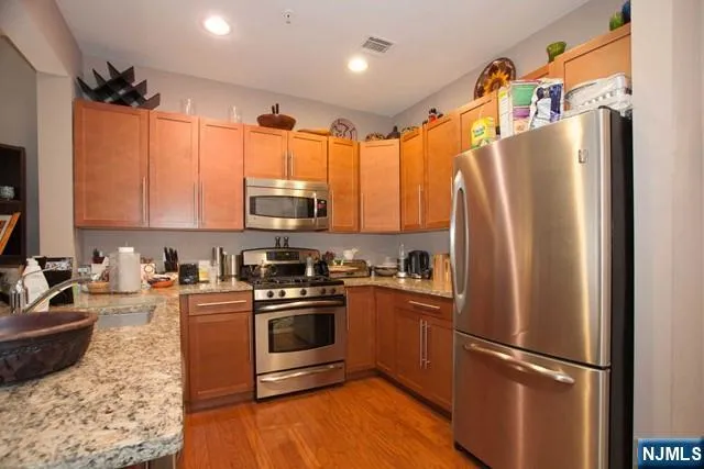 a kitchen with stainless steel appliances granite countertop a refrigerator stove and sink
