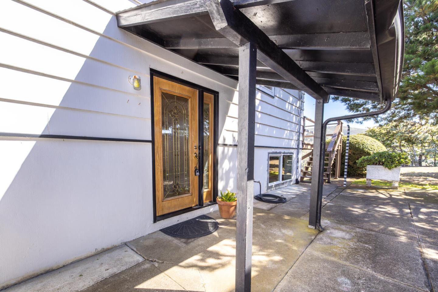 1420 Crespi Drive Pacifica, CA 94044 - Photo 32 of 48 a view of a porch with a table and chairs and floor to ceiling window