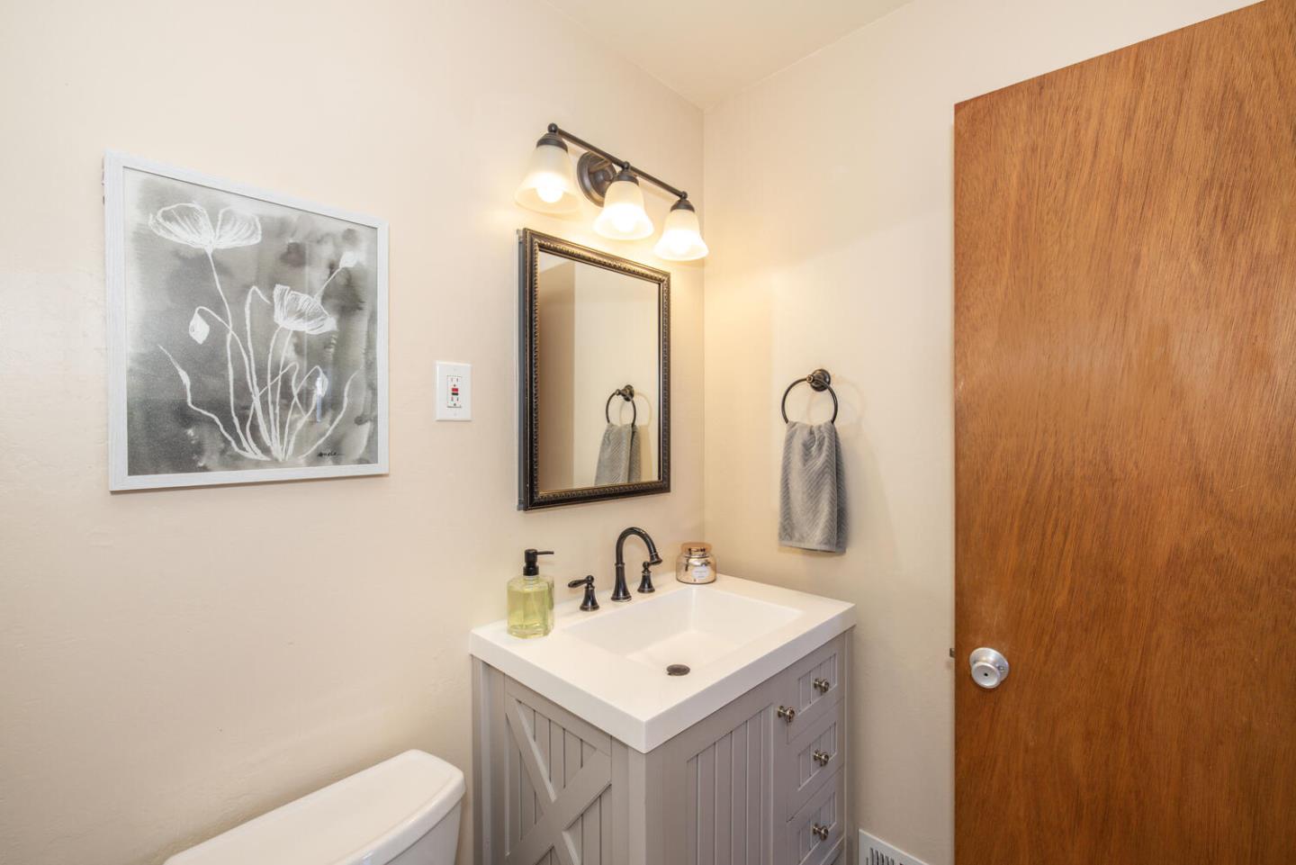 1420 Crespi Drive Pacifica, CA 94044 - Photo 10 of 48 a bathroom with a toilet sink and mirror