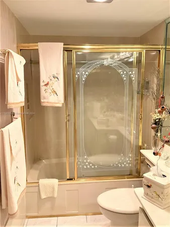 a bathroom with a granite countertop bathtub shower sink and toilet