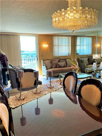 a living room with furniture a chandelier and a large window