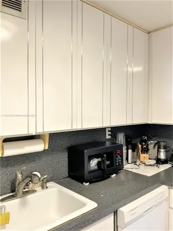 a kitchen with a sink a stove and a microwave