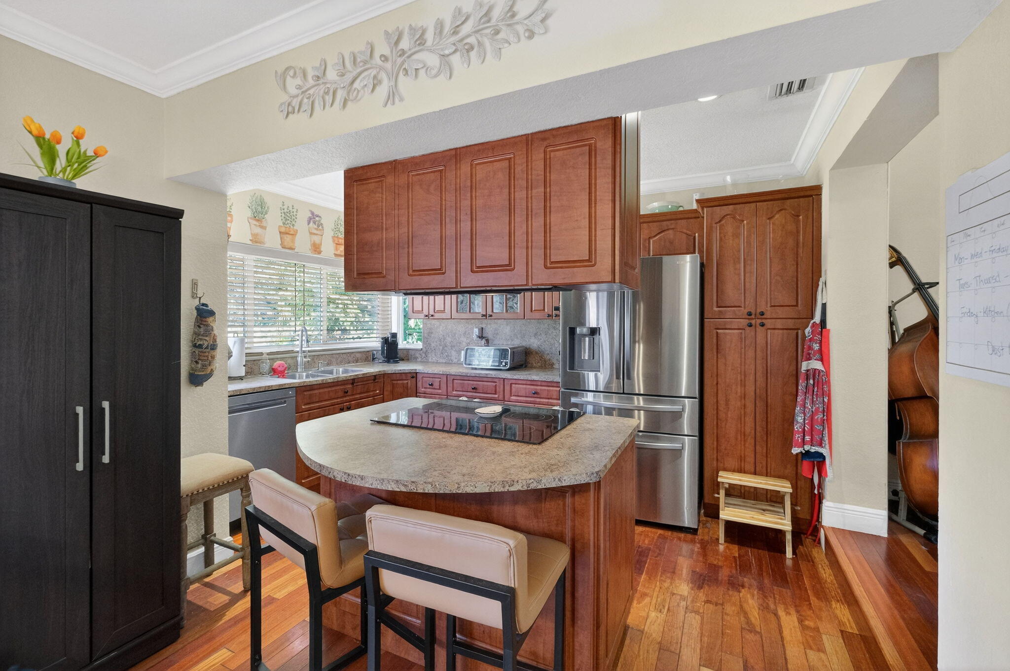 6091 Southwest 12th Street West Miami, FL 33144 - Photo 13 of 38 a kitchen with sink a refrigerator and chairs