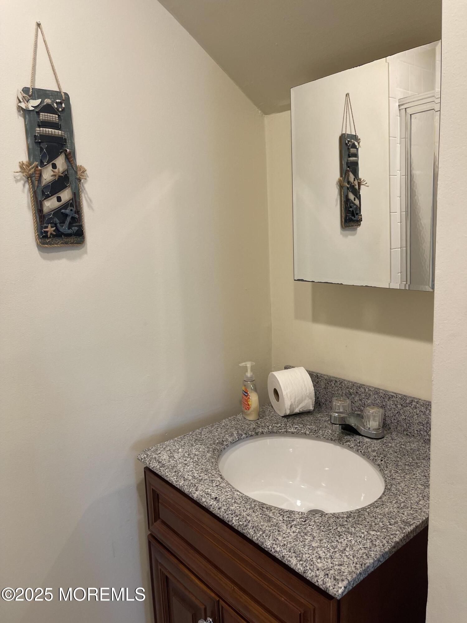 202 Carteret Avenue, Unit B5 Seaside Heights, NJ 08751 - Photo 14 of 17 a bathroom with a granite countertop sink and a mirror