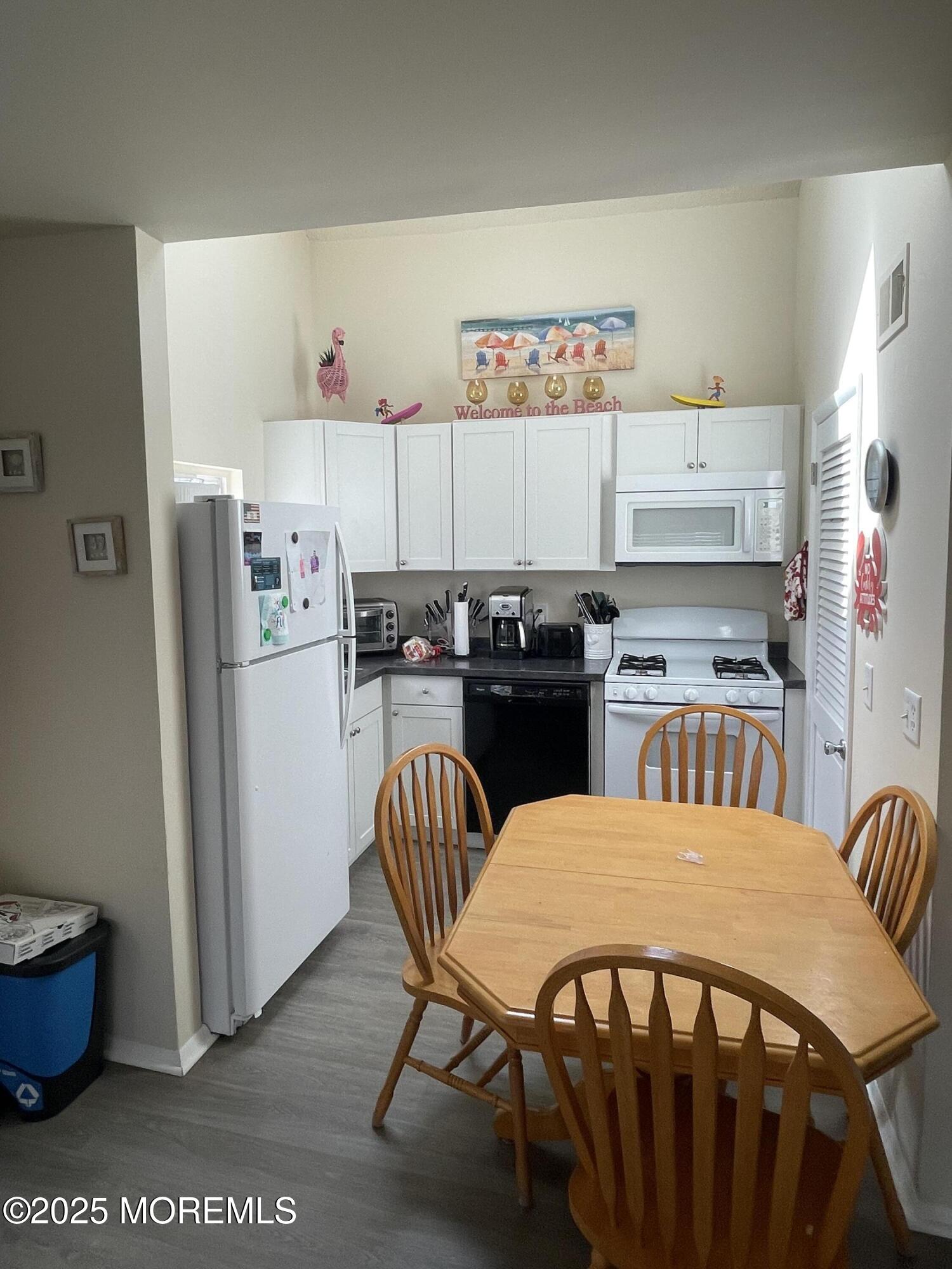 202 Carteret Avenue, Unit B5 Seaside Heights, NJ 08751 - Photo 2 of 17 a kitchen with stainless steel appliances a dining table chairs and refrigerator