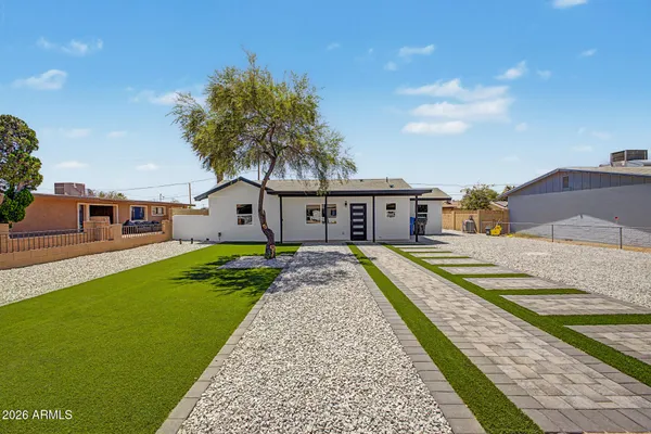a front view of a house with a yard and trees