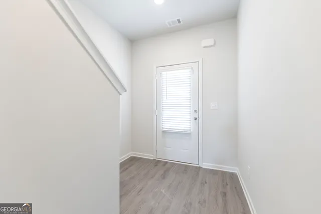 a view of an empty room with wooden floor