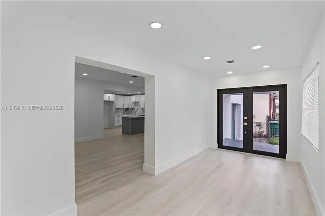 a view of a big room with wooden floor and a window