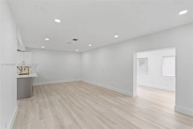 a view of a kitchen with a sink and wooden floor
