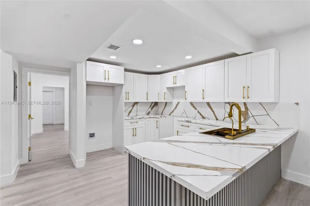 a kitchen with a refrigerator a stove and white cabinets