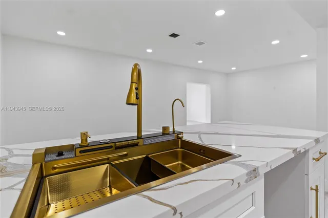 a view of a sink a table and chairs in a kitchen