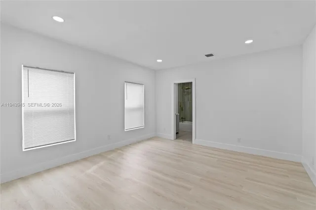 an empty room with windows and closet