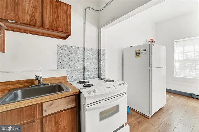 a view of kitchen with refrigerator and wooden floor