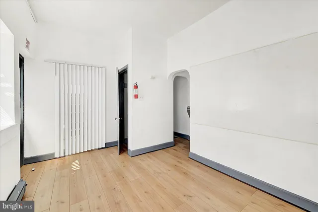 a view of a livingroom with wooden floor and a hallway