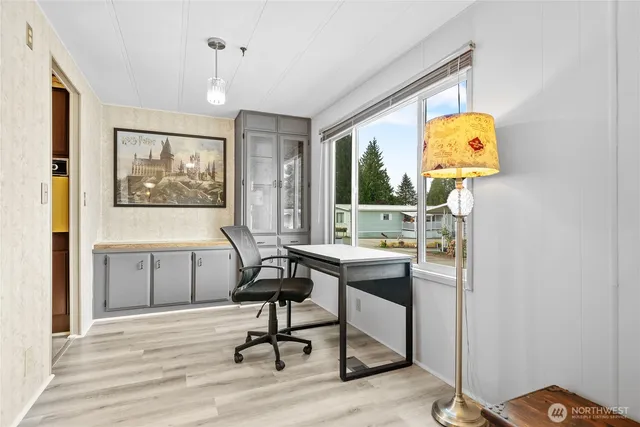 a view of a workspace with furniture and a window