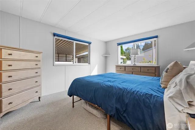a bedroom with a bed window and mirror