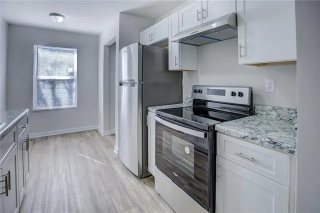 a kitchen with stainless steel appliances granite countertop a stove and a refrigerator