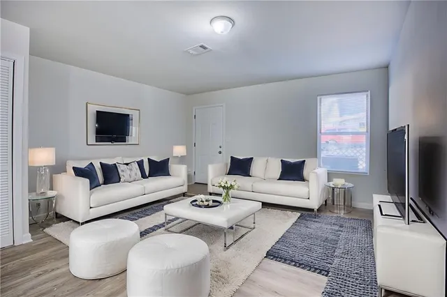 a living room with furniture a flat screen tv and a table