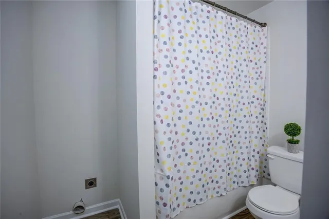 a white toilet sitting next to a shower curtain