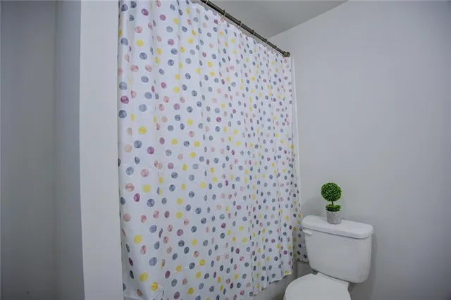 a white toilet sitting next to a shower curtain