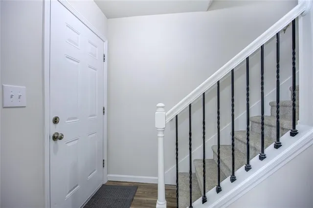 a view of a hallway with wooden floor and staircase