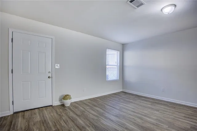 wooden floor in an empty room with a window