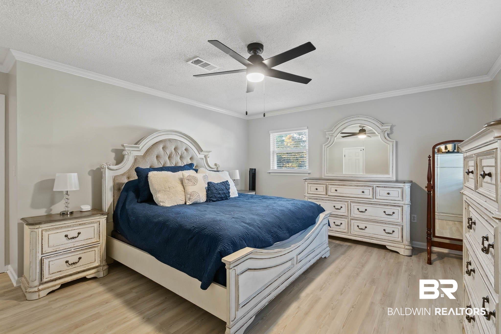 608 Southern Way Daphne, AL 36527 - Photo 18 of 35 Bedroom featuring light wood-type flooring, a ceiling fan, crown molding, and a textured ceiling
