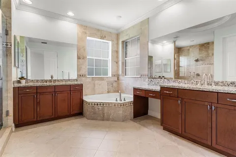 a spacious bathroom with a tub a sink double vanity and a mirror