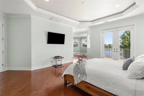 a bedroom with a bed window and a flat screen tv