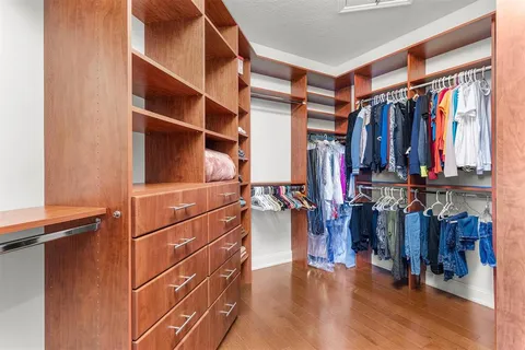a view of walk in closet with clothes and shoes