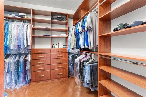 a view of walk in closet with clothes and shoes