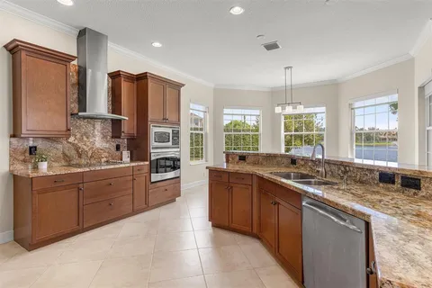a large kitchen with a large window and stainless steel appliances