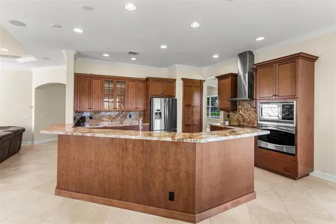 a kitchen with stainless steel appliances granite countertop a refrigerator a stove a sink and a oven