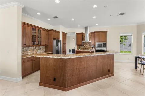 a kitchen with kitchen island granite countertop a sink counter top space appliances and cabinets