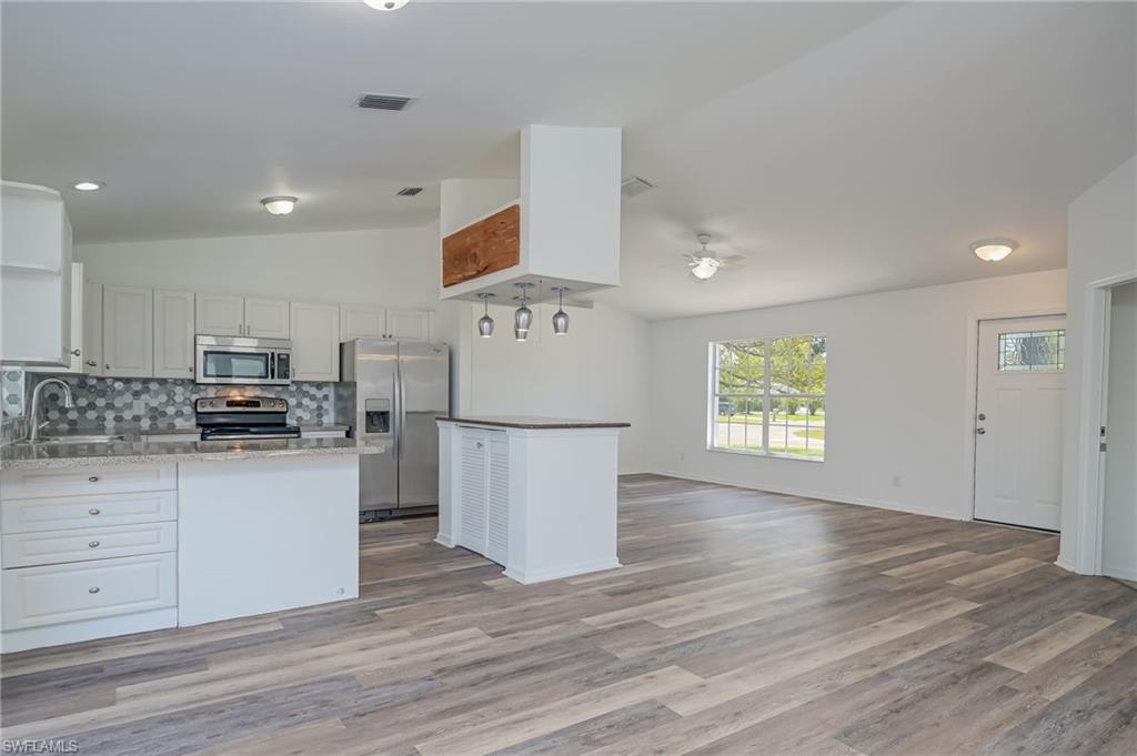 18441 Columbine Road Fort Myers, FL 33967 - Photo 4 of 33 a kitchen with a refrigerator and a stove top oven