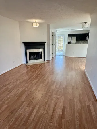 a room with wooden floor and a fireplace