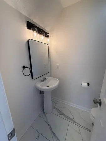 a bathroom with a sink toilet and mirror